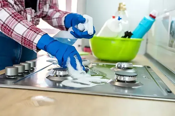 Professional cleaner deep cleaning a kitchen